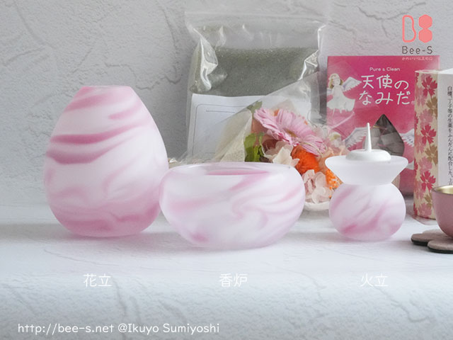 ピンクのガラス仏具と、線香・ろうそく・花などの付属品一式。大切な方への供養に必要なセット